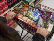 FILE - Jaqueline Benitez, who depends on California's SNAP benefits to help pay for food, shops for groceries at a supermarket in Bellflower, Calif., on Feb. 13, 2023.