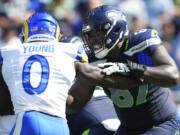 Seattle Seahawks offensive tackle Charles Cross, blocking Los Angeles Rams linebacker Byron Young (0), suffered a sprained big toe on his right foot early in the second half and did not return to the game.