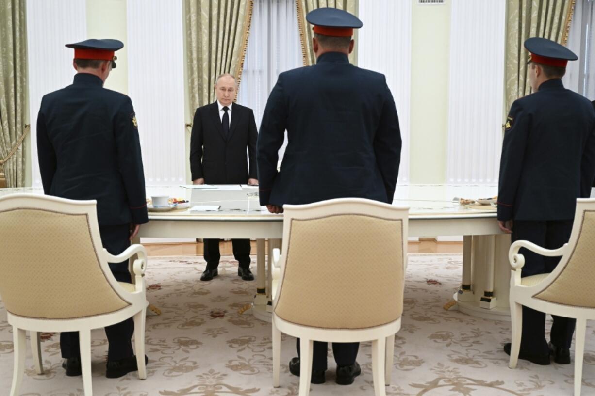 Russian President Vladimir Putin, background center, greets servicemen, participants of Russian special military operation prior to their talks at the Kremlin in Moscow, Russia, Friday, Sept. 29, 2023.