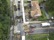 Crews work on a section of Pleasant Street in Leominster, Mass., which was washed out Tuesday, Sept. 12, 2023, after heavy rain fall in the town overnight.