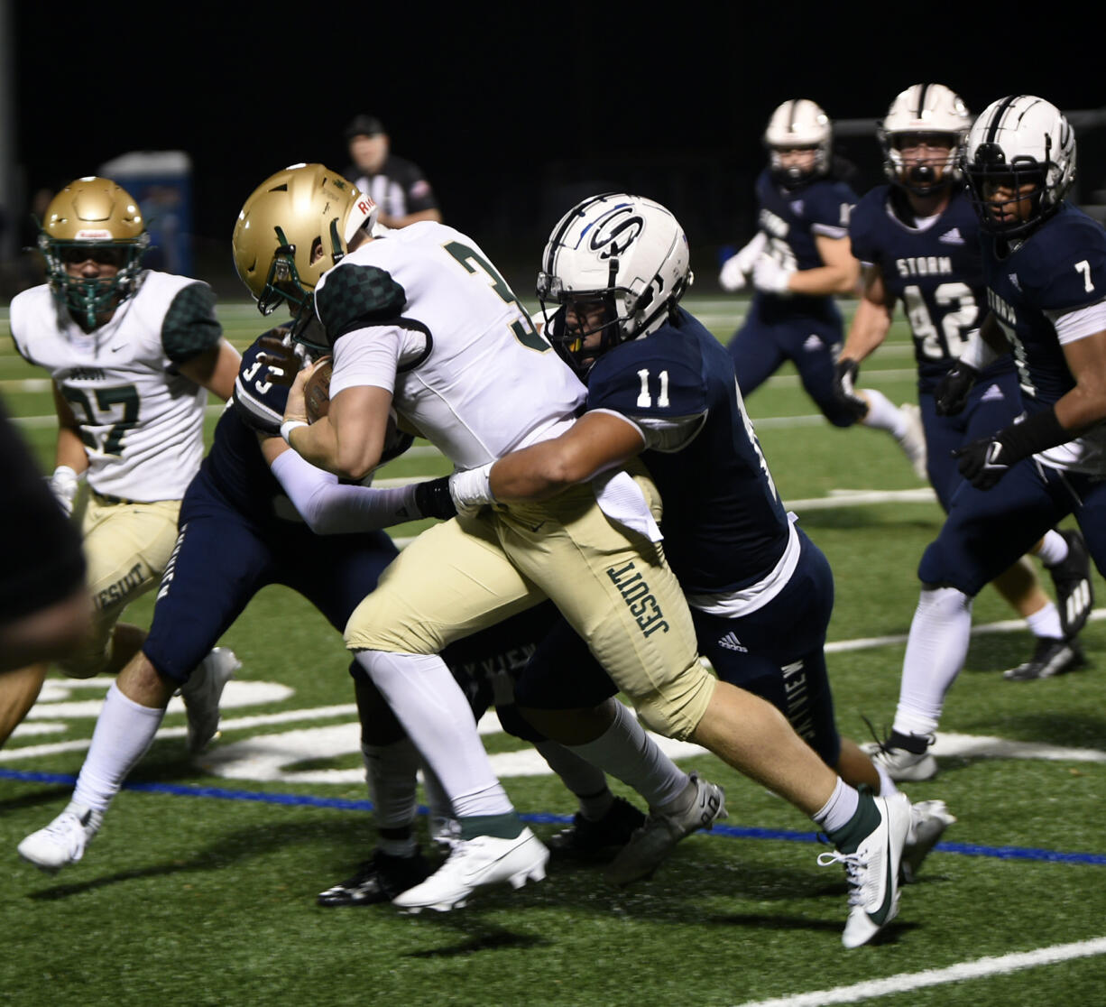 Skyview’s Kaden Hamlin (11) and Kellen Wiggins (33) bring down Jesuit’s Trey Cleeland (3) during the Storm’s 28-0 win at Kiggins Bowl on Friday, Sept. 1, 2023.