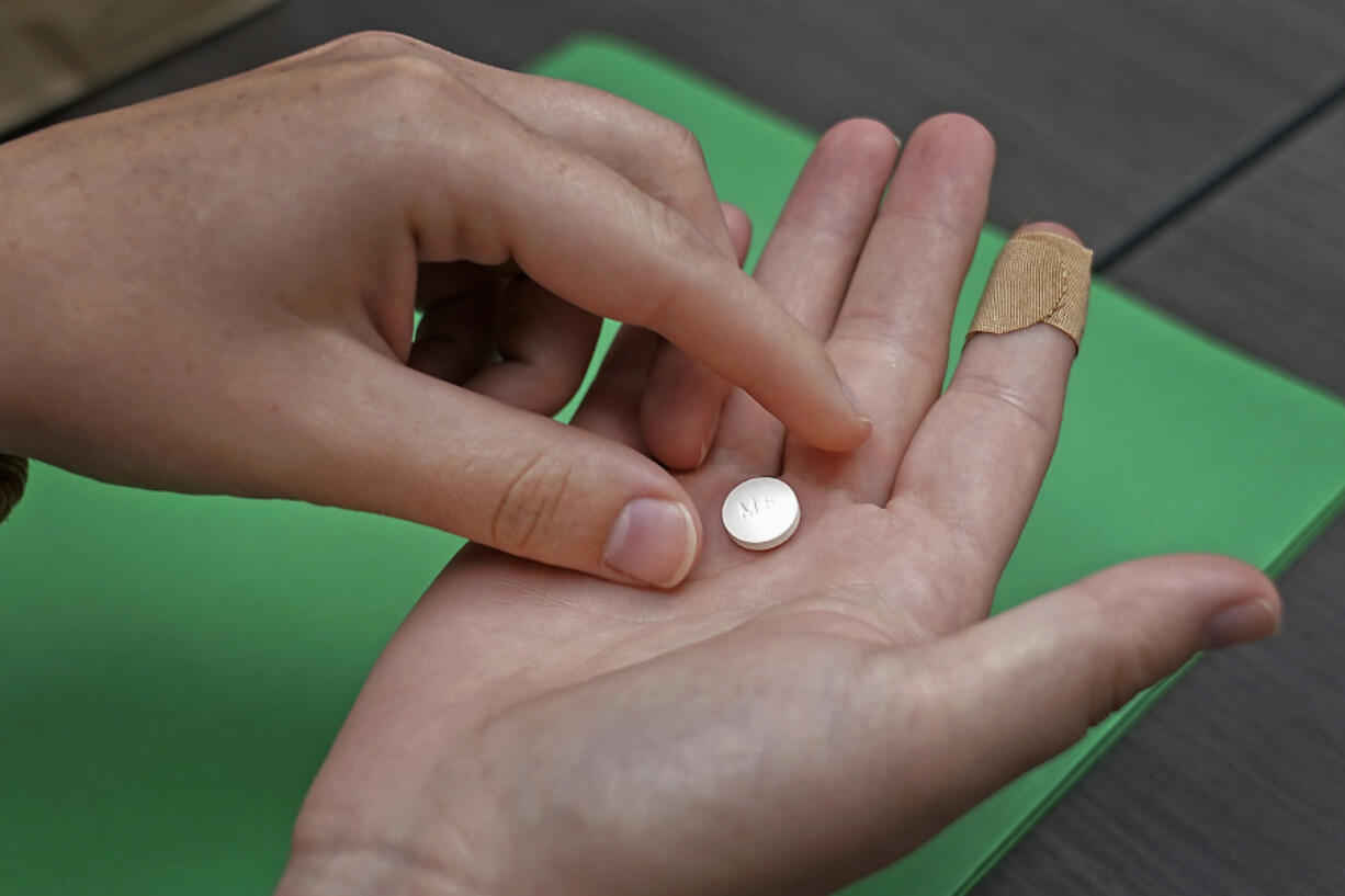 FILE - A patient prepares to take the first of two combination pills, mifepristone, for a medication abortion during a visit to a clinic in Kansas City, Kan., Oct. 12, 2022. The Supreme Court is being asked to reverse an appellate ruling that would cut off mail-order access to a drug used in the most common method of abortion in the United States. In an appeal filed Friday, Sept. 8, 2023, Danco Laboratories, the manufacturer of mifepristone, argued that federal judges should not second-guess the Food and Drug Administration's approval of the drug or the conditions under which it is dispensed. The Biden administration also was expected to file an appeal.