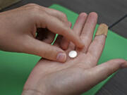 FILE - A patient prepares to take the first of two combination pills, mifepristone, for a medication abortion during a visit to a clinic in Kansas City, Kan., Oct. 12, 2022. The Supreme Court is being asked to reverse an appellate ruling that would cut off mail-order access to a drug used in the most common method of abortion in the United States. In an appeal filed Friday, Sept. 8, 2023, Danco Laboratories, the manufacturer of mifepristone, argued that federal judges should not second-guess the Food and Drug Administration's approval of the drug or the conditions under which it is dispensed. The Biden administration also was expected to file an appeal.