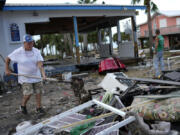 Employee Lisa Bell dumps out a shovel full of mud as business owners and employees start cleaning up at the storm-damaged business The Marina, in Horseshoe Beach, Fla., Thursday, Aug. 31, 2023, one day after the passage of Hurricane Idalia.