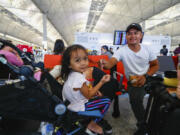 Filipino tourist Andres at right with his daughter wait for rescheduling after their flight returning to the Philippines was cancelled at the Hong Kong International Airport, in Hong Kong, on Friday, Sept. 1, 2023. Hundreds of flights were cancelled as most of Hong Kong and other parts of southern China ground to a near standstill as Super Typhoon Saola edged closer Friday.