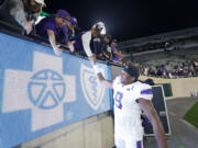 Washington's Michael Penix Jr. greets fans following an NCAA college football game against Michigan State, Saturday, Sept. 16, 2023, in East Lansing, Mich. Washington won 41-7.