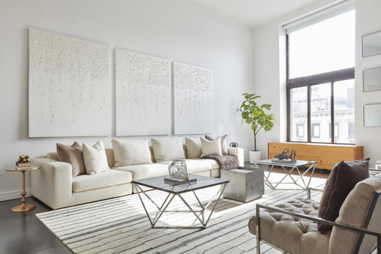 White-on-white artwork and white upholstery help make this living space feel modern and fresh.