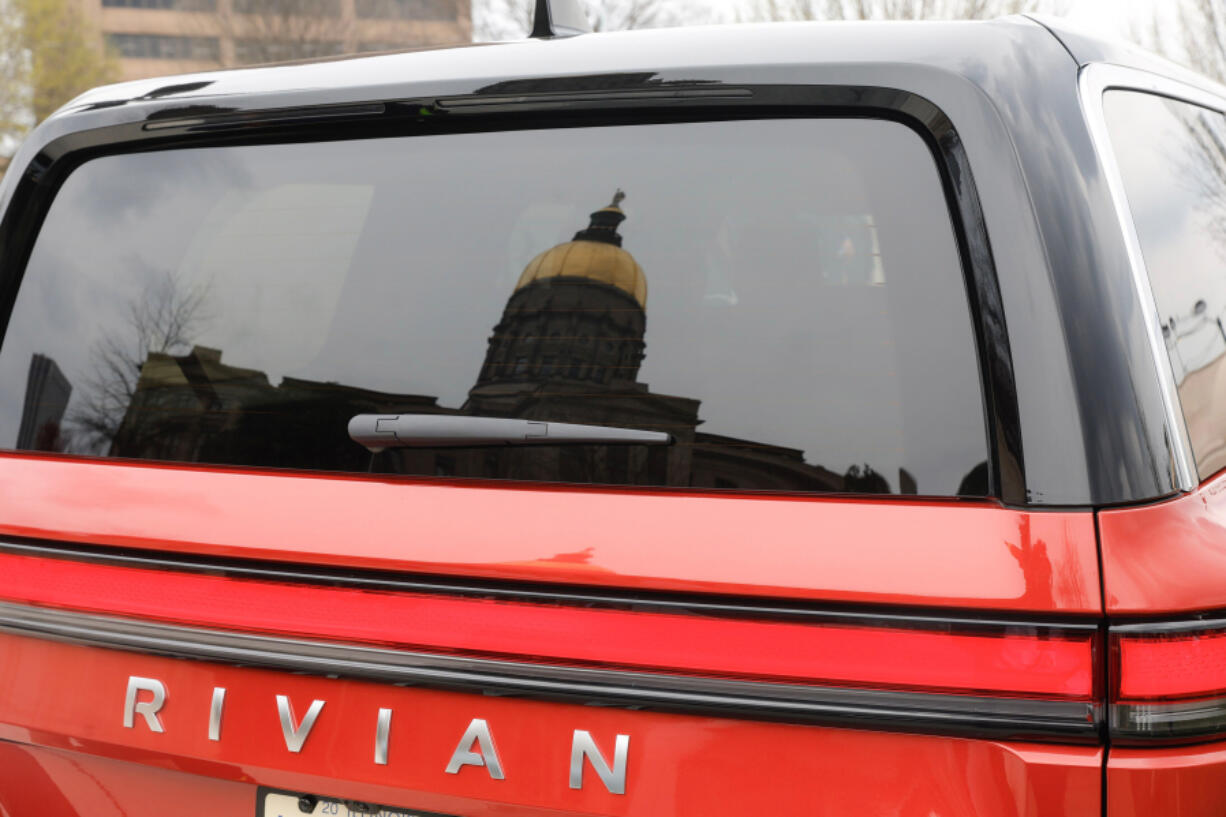 Views of the Georgia State Capitol reflected in the window of a Rivian electric vehicle on Wednesday, March 1, 2023.