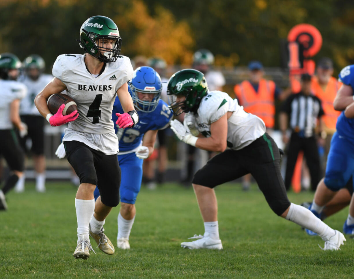 Woodland junior Elijah Andersen, left, runs with the ball on Sept. 7, 2023, during a game against La Center at La Center High School.