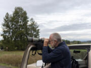 Longtime volunteer and birder Roger Windemuth peers through his spotting scope at the Ridgefield National Wildlife Refuge. Windemuth has been visiting the refuge and compiling a weekly bird-sighting list there for 17 years.