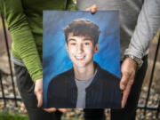 Linnea, left, and Matt Justis hold a photo of their son Zain Justis. Zain died in 2021 from primary mediastinal large B-cell lymphoma and his parents created the foundation to raise awareness of and fund research for rare types of cancer that affect kids and young adults.