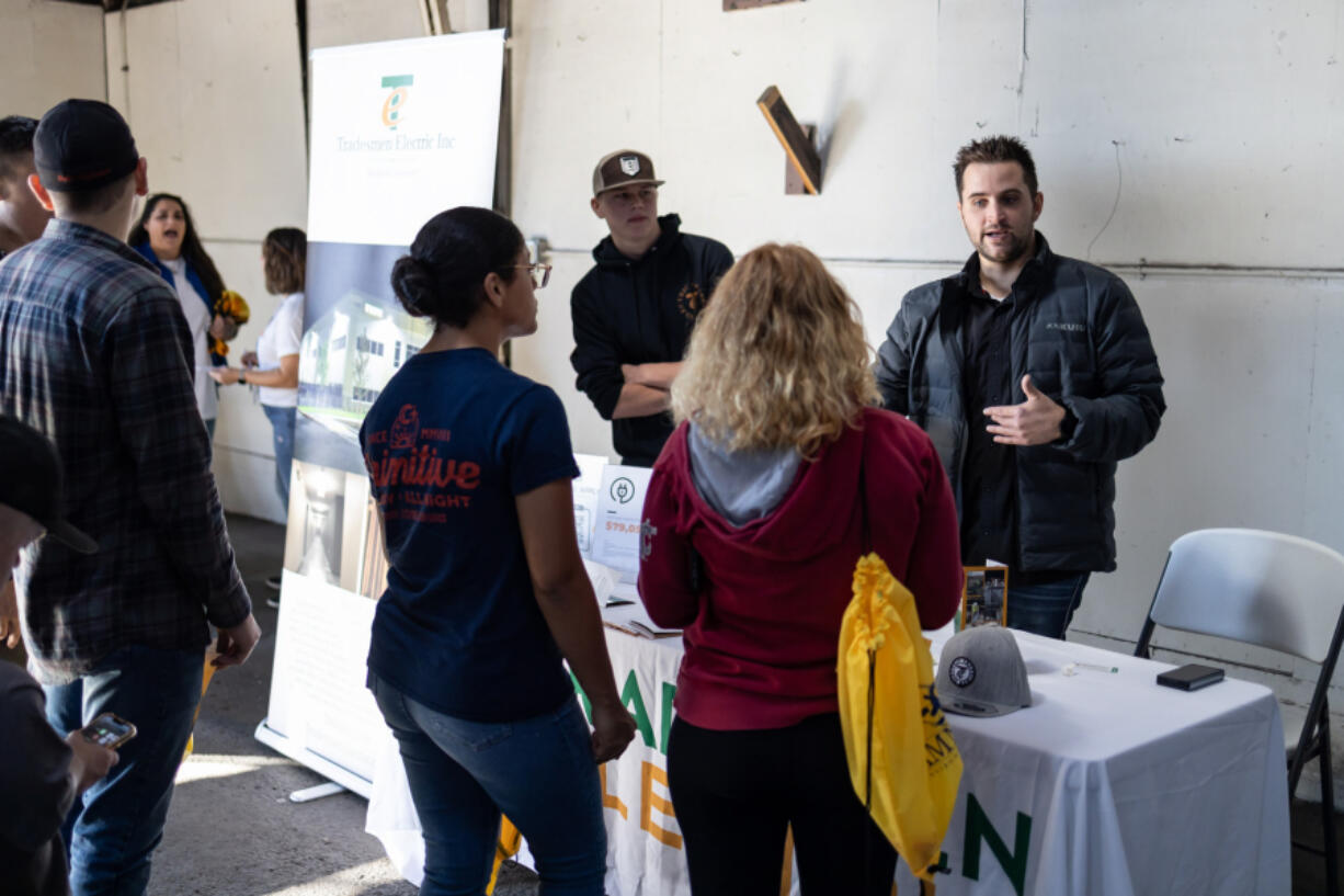 Jack Dobrava, left, and Tanner Linge from Tradesmen Electric talks to high school students about career options at the Dozer Day Career Fair.