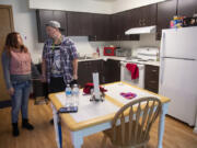 Katie Vongthongthip, left, and Chance Newbill talk in the kitchen in their new apartment.