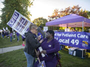 Judy Brunskill, left, registration representative for Kaiser Permanente, pauses to talk with longtime colleague Brenda Horey, a release of information specialist, as fellow workers strike in front of the Cascade Park Medical Office on the strike's third and final day. Horey, who is dealing with a leg injury and is battling breast cancer, has worked with Brunskill since 1986.