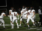 The Battle Ground Tigers celebrate after Artem Bahnyuk (1) recovered a fumble during a game at McKenzie Stadium on Thursday, Oct. 12, 2023.