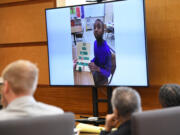 A school photo of Karreon Franks is displayed on a television Wednesday at the Clark County Courthouse during a murder trial. Karreon's adoptive parents Felicia Adams, right, and Jesse Franks, center, are being tried on second-degree murder and homicide by abuse in the 2020 death of the 15-year-old.