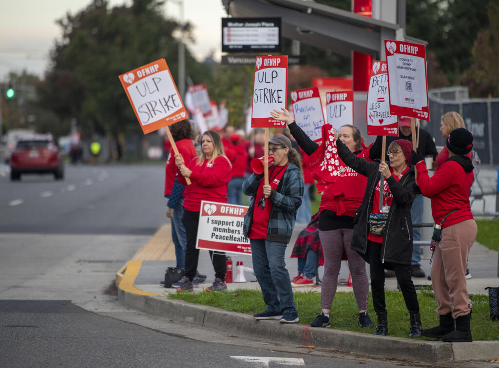 Health care workers on strike hold signs Monday, Oct. 23, 2023, at PeaceHealth Southwest Medical Center. Members of the Oregon Federation of Nurses and Health Professionals are striking for five days over low wages, low staffing levels and prolonged contract negotiations with PeaceHealth management.