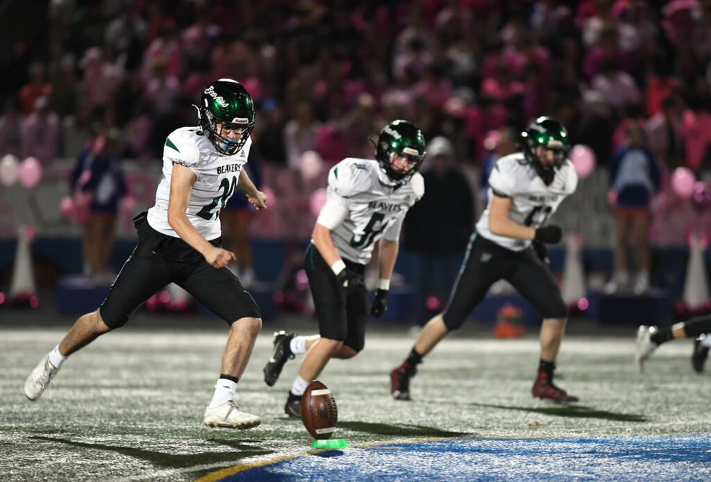 Woodland senior Diego Almodovar, left, kicks the ball off after a touchdown Friday, Oct, 27, 2023, during the Beavers’ 28-21 win against Ridgefield at Ridgefield High School. With the win, Woodland captured its first 2A Greater St. Helens League title since 2007.