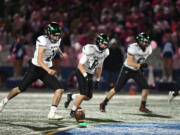 Woodland senior Diego Almodovar, left, kicks the ball off after a touchdown Friday, Oct, 27, 2023, during the Beavers’ 28-21 win against Ridgefield at Ridgefield High School. With the win, Woodland captured its first 2A Greater St. Helens League title since 2007.