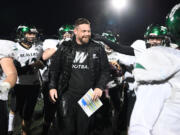 Players celebrate with Woodland head coach Sean McDonald after he was doused with water Friday, Oct, 27, 2023, after the Beavers’ 28-21 win against Ridgefield at Ridgefield High School. With the win, Woodland captured its first 2A Greater St. Helens League title since 2007.