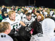 Woodland senior Carter Conway, from left, junior Charles Elkinton, sophomore Isaiah Mattison, and other players celebrate Friday, Oct, 27, 2023, after the Beavers’ 28-21 win against Ridgefield at Ridgefield High School. With the win, Woodland captured its first 2A Greater St. Helens League title since 2007.