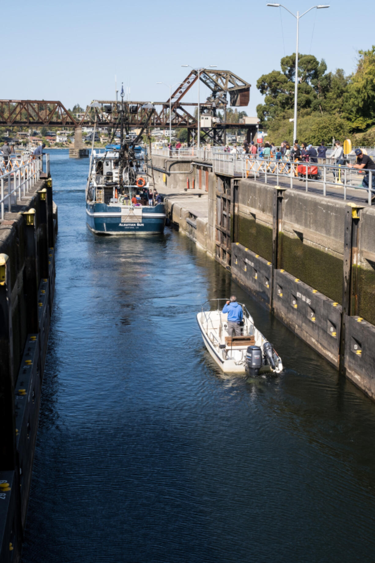 Boats pass through the locks in Ballard as visitors watch Sept. 18, 2022. Formally opened in 1917, the Ballard Locks are the nation's busiest, passing up to 50,000 vessels each year.