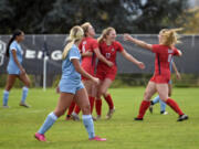 Lower Columbia College's Sydney Lulay (13) celebrates with teammates Rhyli Grim (16) and Molly Romanchock (18) after scoring the Red Devils' first goal in an NWAC women's soccer match on Wednesday, Oct. 25, 2023, at Kim Christensen Field.