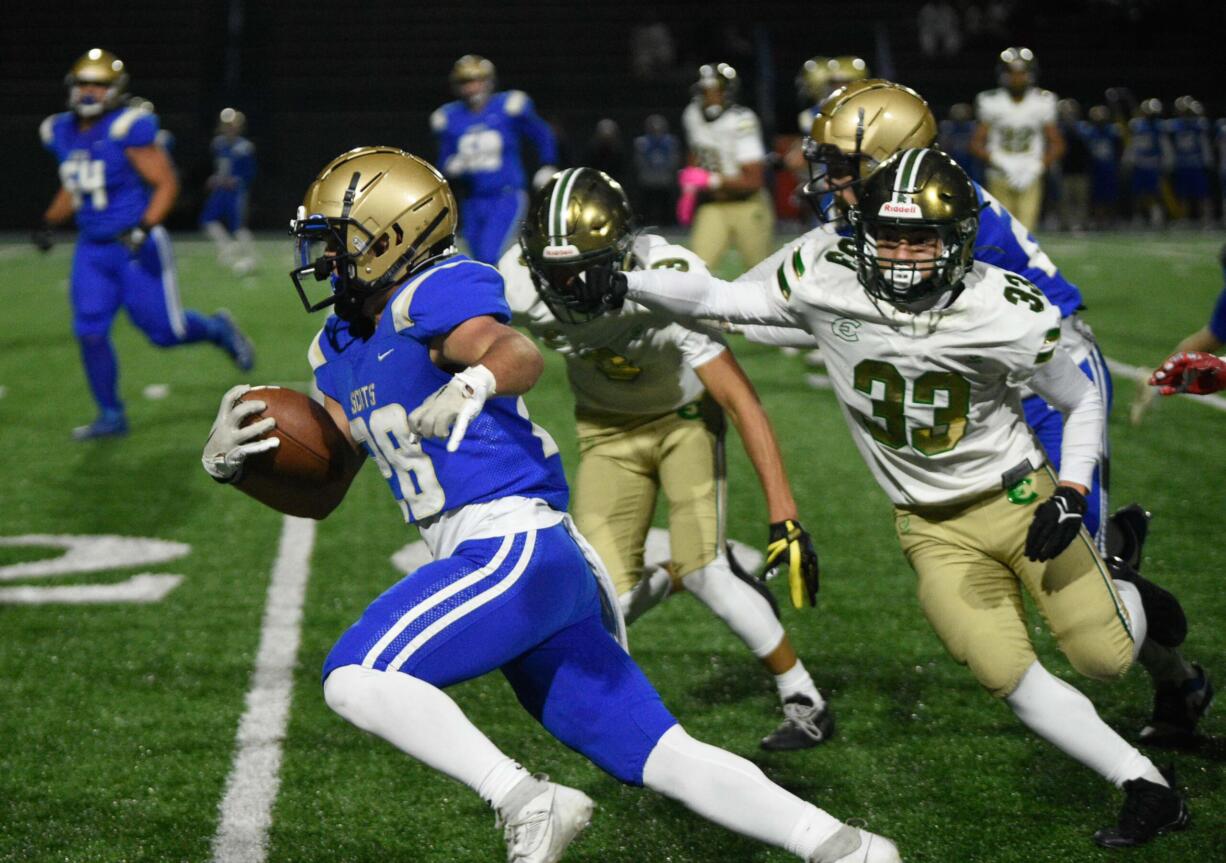 Kelso's Aden Mintonye, left, tiptoes along the sideline while being chased by multiple Evergreen defenders during a 3A GSHL football game on Friday, Oct. 27, 2023, at Kelso High School.