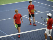 Tommy James (left) and Aidan Brasier of Camas chat with Nathan Chen of Camas during a change-over in the doubles final at the Class 4A boys tennis district tournament at Vancouver Tennis Center on Saturday, Oct. 21, 2023.