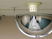 FILE - In this Nov. 18, 2015, file photo, a mirror on the ceiling of a hallway in a ward at the Western State Hospital in Lakewood, Wash. is shown. Hundreds of mentally ill patients at Washington state's largest psychiatric hospital are forced to live in conditions that don't meet federal health and safety standards, while overworked nurses and psychiatrists say they must navigate a management system that punishes whistleblowers and fires non-conformers, despite critical staffing shortages. For years, federal regulators have continuously cited the 800-bed facility for violating health and safety standards and a surprise inspection last month found that the hospital continues to put patients at risk. (AP Photo/Ted S.