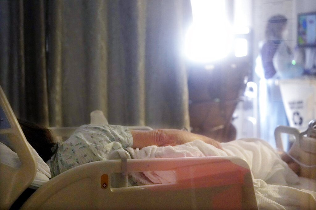 A patient lies in a bed in the acute care unit of Harborview Medical Center in January 2022 in Seattle.