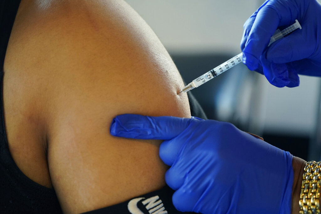 FILE - A Jackson, Miss., resident receives a Pfizer booster shot from a nurse at a vaccination site Feb. 8, 2022.  Pfizer is asking the Food and Drug Administration to expand use of its updated COVID-19 booster shot to children ages 5 to 11, Monday, Sept. 26. Already 4.4 million Americans have received one of the updated boosters since they rolled out earlier this month for anyone 12 and older.  (AP Photo/Rogelio V.