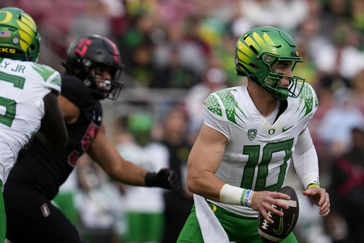 Oregon quarterback Bo Nix, right, looks for a receiver against Stanford during the first half of an NCAA college football game, Saturday, Sept. 30, 2023, in Stanford, Calif. (AP Photo/Godofredo A.
