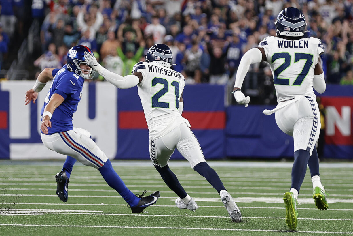 Seattle Seahawks cornerback Devon Witherspoon (21) cuts behind New York Giants quarterback Daniel Jones (8) after intercepting a pass to run it back for a touchdown during the third quarter of an NFL football game, Monday, Oct. 2, 2023, in East Rutherford, N.J.