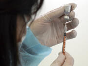 A health worker prepares a dose of the Pfizer COVID-19 vaccine.