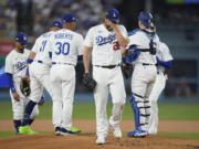 Los Angeles Dodgers starting pitcher Clayton Kershaw, center, reacts as he exits during the first inning in Game 1 of a baseball NL Division Series against the Arizona Diamondbacks, Saturday, Oct. 7, 2023, in Los Angeles.