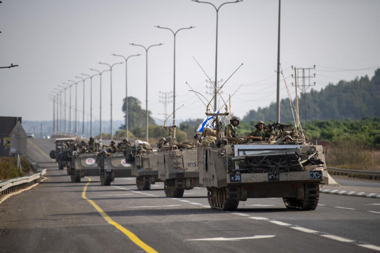 Israeli soldiers carry supplies near the border with Lebanon on Tuesday, Oct. 10, 2023.