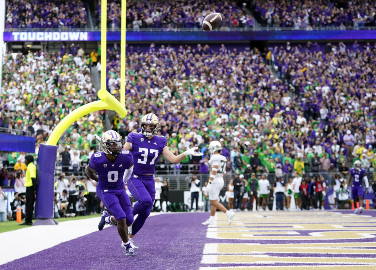 Washington wide receiver Giles Jackson (0) celebrates after scoring a touchdown with teammate Jack Westover (37) during the first half of an NCAA college football game against Oregon, Saturday, Oct. 14, 2023, in Seattle.