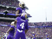 Washington wide receiver Giles Jackson, top, is lifted up by wide receiver Germie Bernard (4) after scoring a touchdown against Oregon during the first half of an NCAA college football game, Saturday, Oct. 14, 2023, in Seattle.