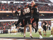 Oregon State tight end Jack Velling, center, celebrates after scoring a touchdown against UCLA with Silas Bolden, left, and Deshaun Fenwick, right, during the first half of an NCAA college football game Saturday, Oct. 14, 2023, in Corvallis, Ore.