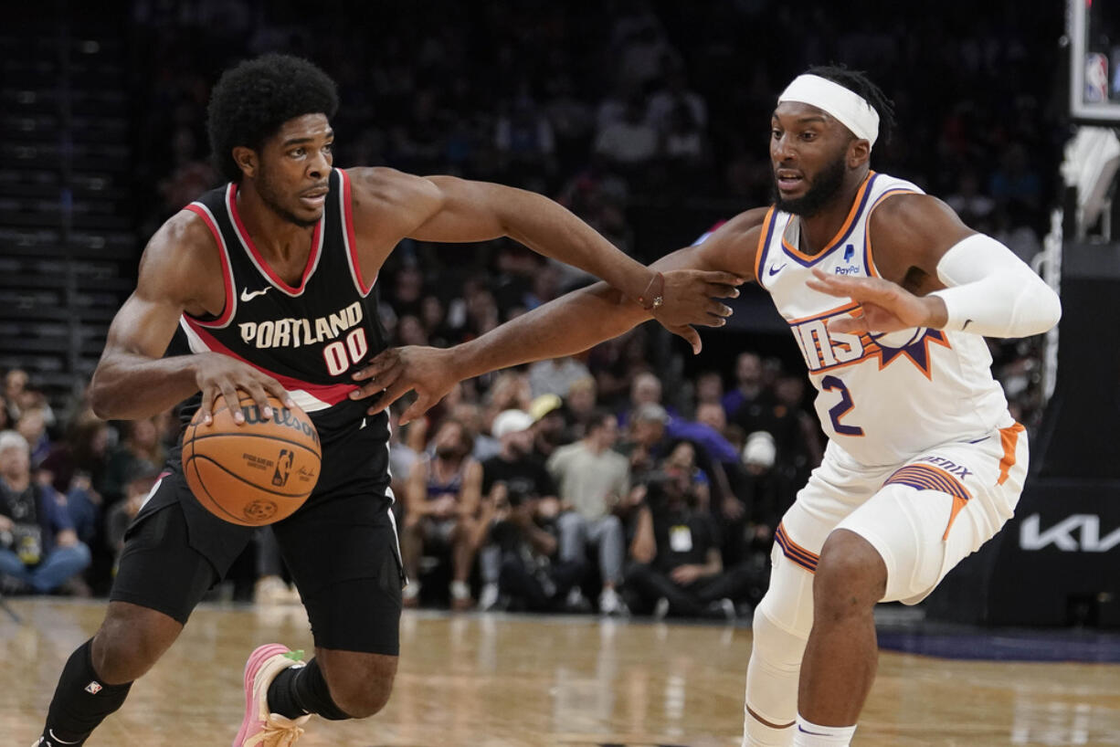 Phoenix Suns' Josh Okogie (2) guards against Portland Trail Blazers' Scoot Henderson (00) during the first half of a preseason NBA basketball game, Monday, Oct. 16, 2023, in Phoenix.