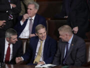 Rep. Jim Jordan, R-Ohio, chairman of the House Judiciary Committee, seated center, talks to Rep. Warren Davidson, R-Ohio, right, and a House staff member, left, as Republicans try to elect Jordan, a top Donald Trump ally, to be the new House speaker, at the Capitol in Washington, Tuesday, Oct. 17, 2023, as former Speaker of the House Rep. Kevin McCarthy, R-Calif., sits behind them. (AP Photo/J.