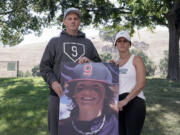 Padrig and Gina Fahey hold a photo of their son, Braden, 12, as they stand for a portrait in California on Wednesday, Sept. 6, 2023. Braden collapsed at football practice in August 2022 and died of a malformed blood vessel in the brain. The Faheys couldn’t understand how Braden’s face appeared on the cover of the book “Cause Unknown,” which was co-published by an anti-vaccine group led by Robert F. Kennedy Jr., or why his name appeared inside it. (AP Photo/Godofredo A.