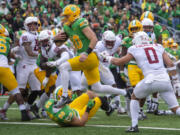 Oregon quarterback Bo Nix (10) scores a touchdown against Washington State during the first half of an NCAA college football game Saturday, Oct. 21, 2023, in Eugene, Ore.