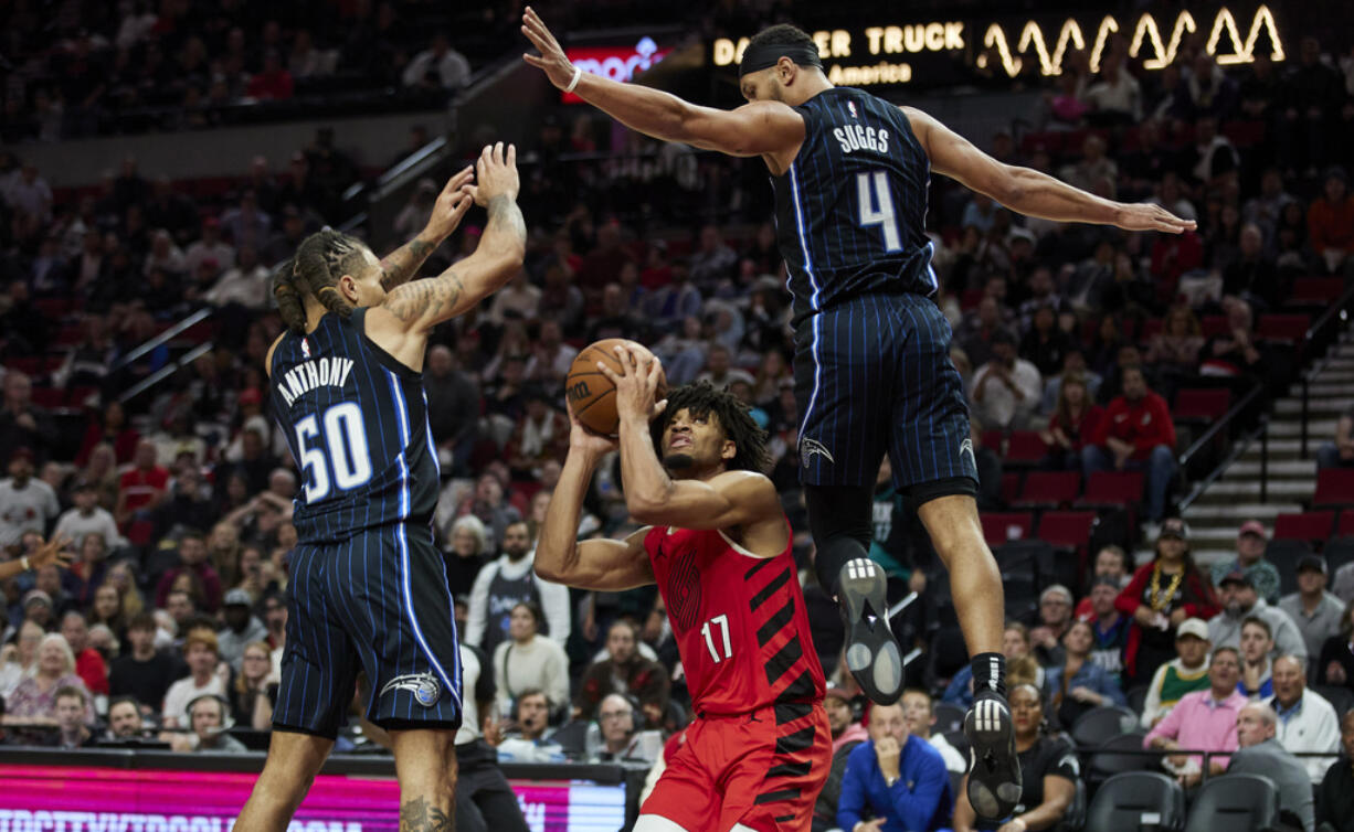 Portland Trail Blazers guard Shaedon Sharpe, center, looks to shoot from between Orlando Magic guard Jalen Suggs, right, and guard Cole Anthony during the second half of an NBA basketball game in Portland, Ore., Friday, Oct. 27, 2023.