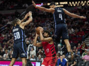 Portland Trail Blazers guard Shaedon Sharpe, center, looks to shoot from between Orlando Magic guard Jalen Suggs, right, and guard Cole Anthony during the second half of an NBA basketball game in Portland, Ore., Friday, Oct. 27, 2023.