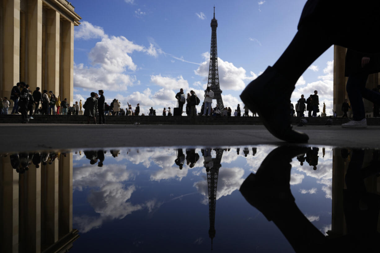 The Eiffel Tower is reflected in a puddle Tuesday in Paris.