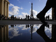 The Eiffel Tower is reflected in a puddle Tuesday in Paris.