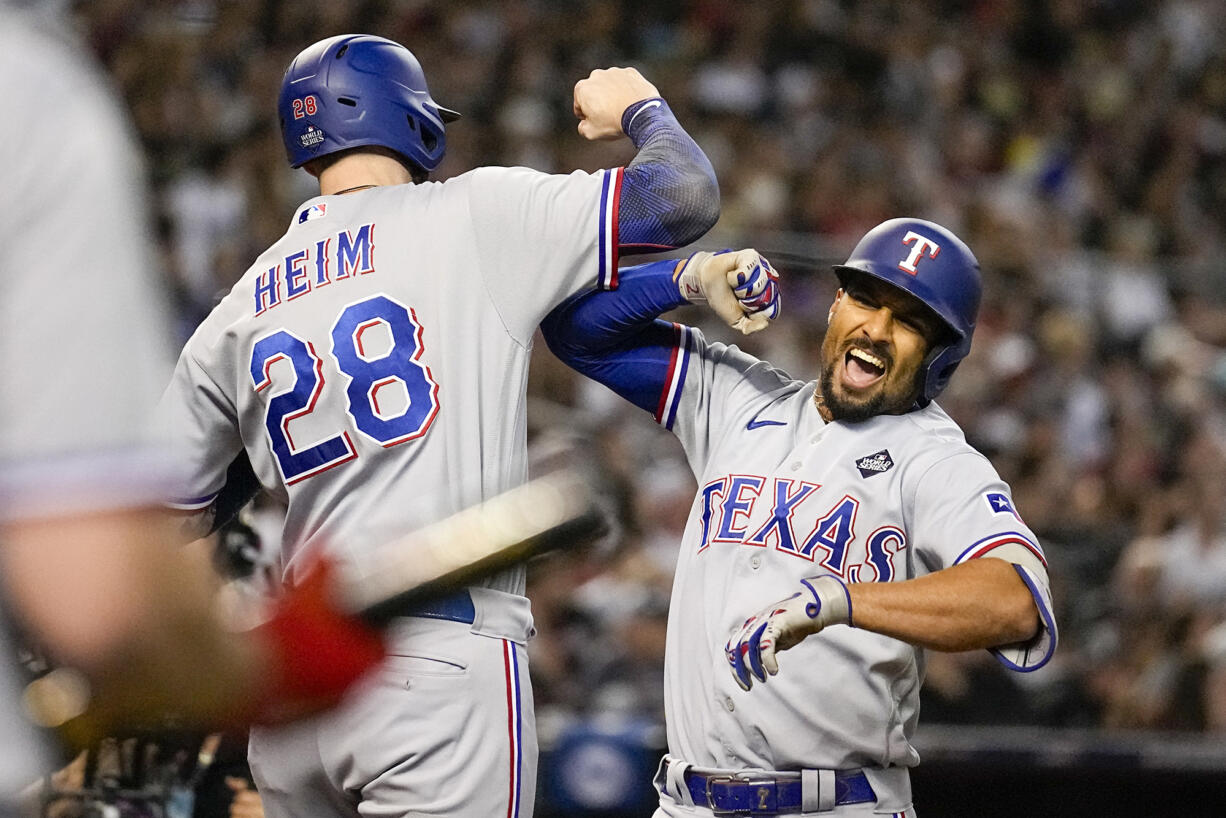 Texas Rangers' Marcus Semien, right, celebrates his three-run home run with Jonah Heim during the third inning in Game 4 of the baseball World Series against the Arizona Diamondbacks Tuesday, Oct. 31, 2023, in Phoenix.