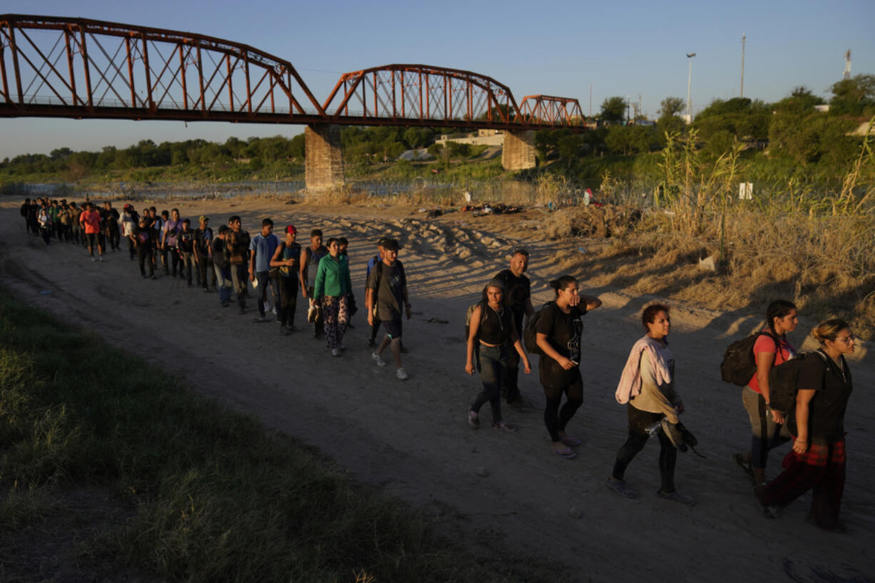 FILE - Migrants who crossed the Rio Grande and entered the U.S. from Mexico are lined up for processing by U.S. Customs and Border Protection, Sept. 23, 2023, in Eagle Pass, Texas. Most people in the U.S. see Mexico as an essential partner to stop drug trafficking and illegal border crossings, even as they express mixed views of Mexico's government, according to a new poll.